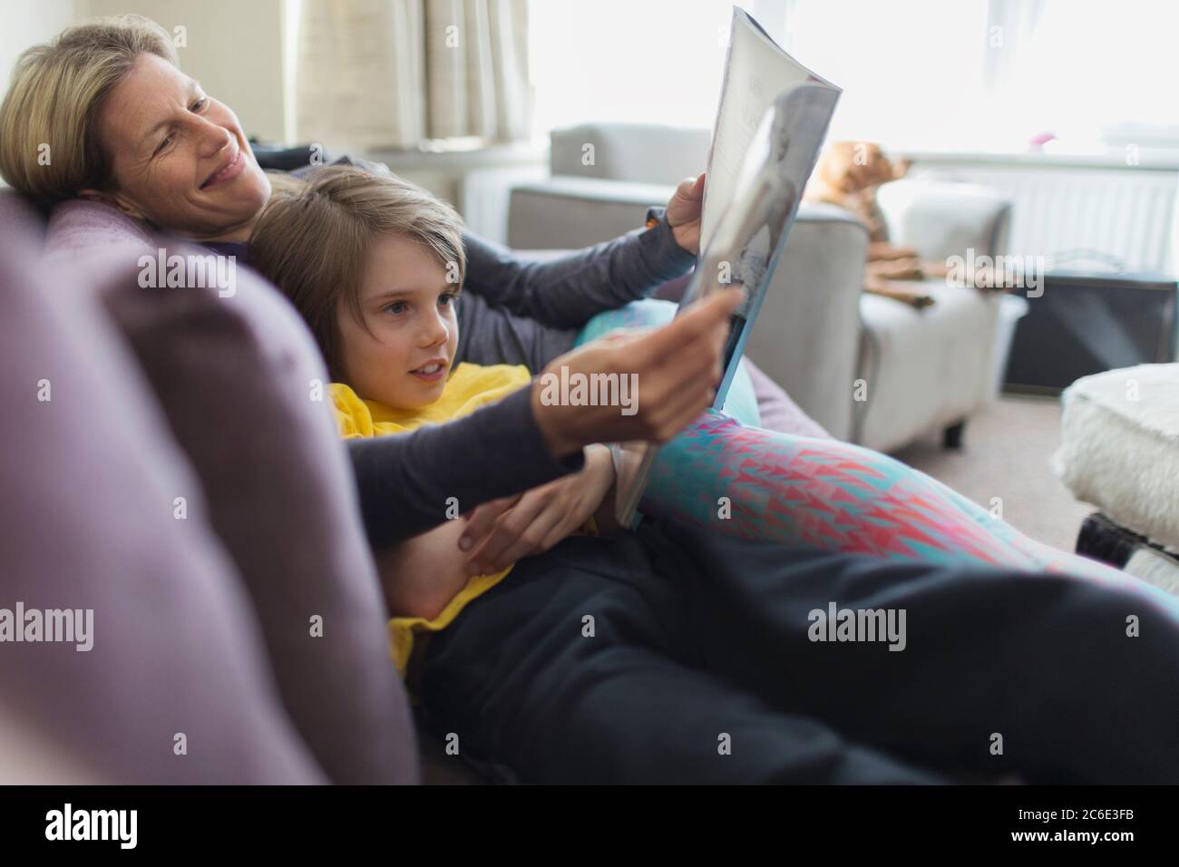 Glückliche Mutter und Sohn lesen Buch auf Wohnzimmer Sofa Stockfoto