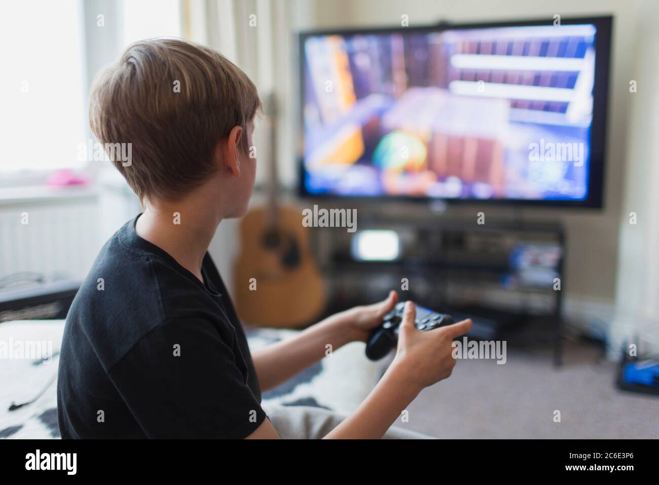 Junge spielt Videospiel am Fernseher im Wohnzimmer Stockfoto