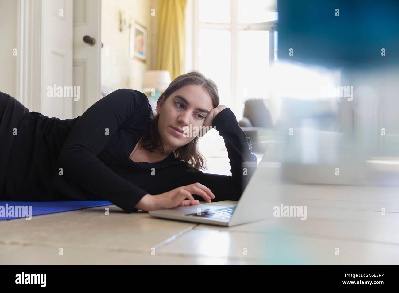 Teenager Mädchen Yoga am Laptop von zu Hause aus Stockfoto