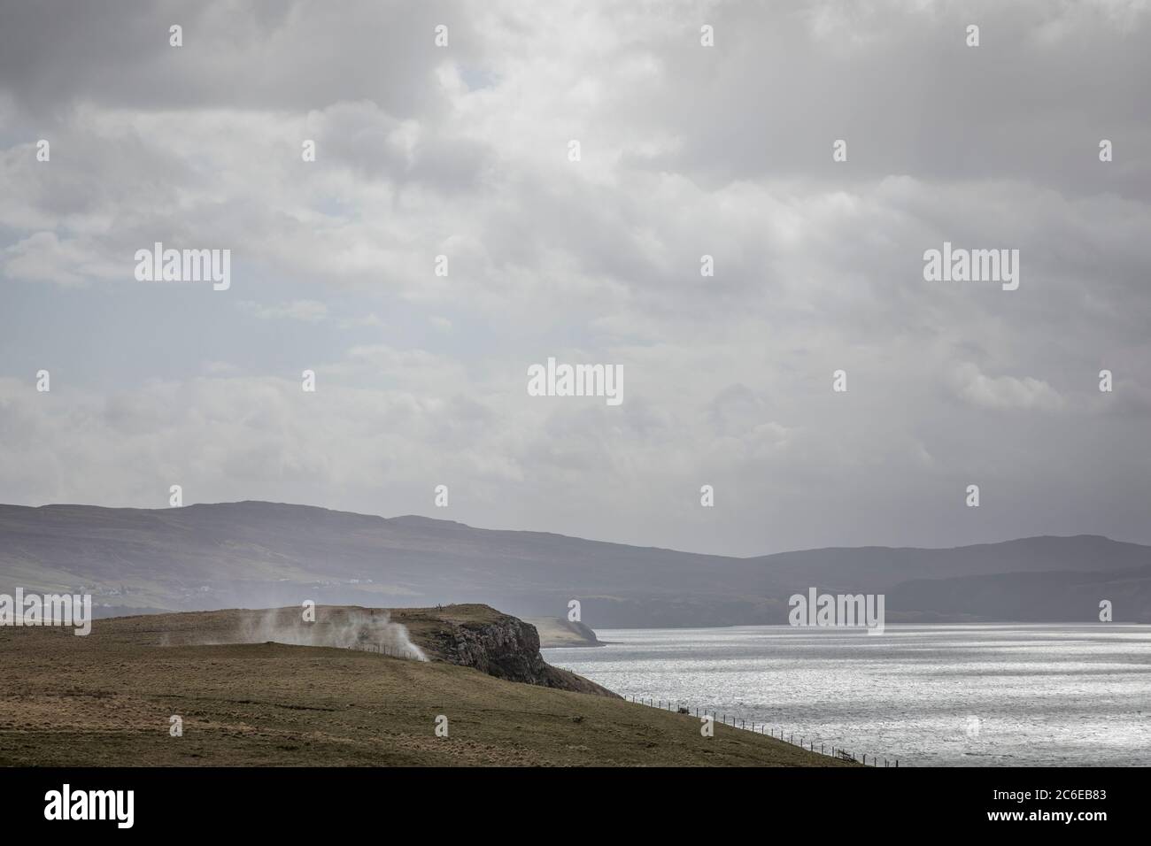 Der Wind an Land erzeugt eine Sprühdüse auf der Landzunge auf der Waternish Peninsula, Isle of Skye, Schottland. Stockfoto