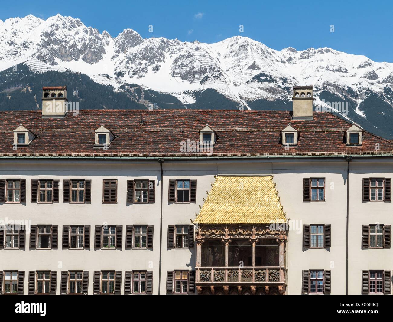 INNSBRUCK, ÖSTERREICH - 5. MAI 2016: Das ikonische kupfergeflieste Goldene Dachl in der Altstadt von Innsbruck, Österreich. Die schneebedeckten Gipfel der Alpen Stockfoto