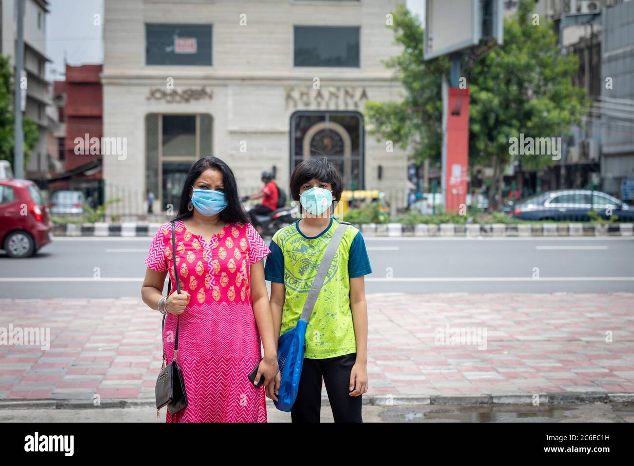 Indische Frau und ihr Sohn tragen Gesichtsmaske und gehen zum Einkaufen in den berühmten South Ex Markt in Neu Delhi, Indien Stockfoto