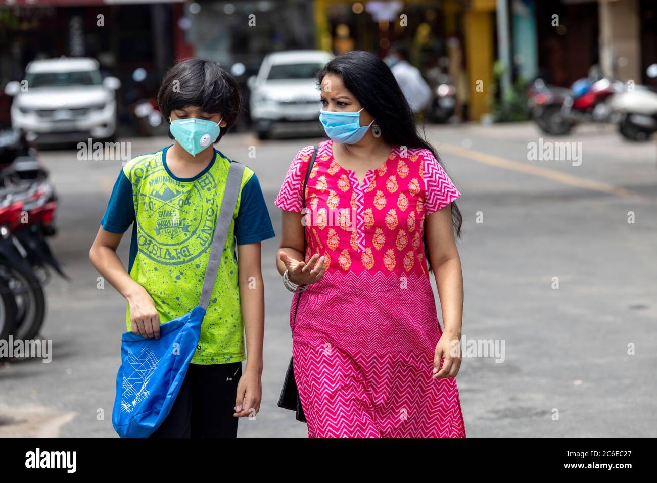 Indische Frau und ihr Sohn tragen Gesichtsmaske und gehen zum Einkaufen in den berühmten South Ex Markt in Neu Delhi, Indien Stockfoto