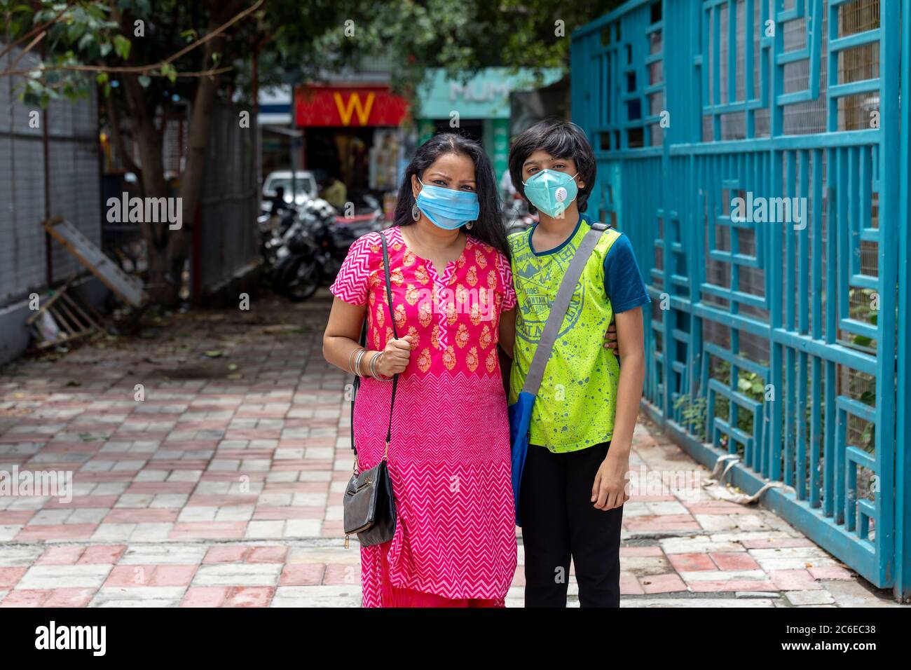 Indische Frau und ihr Sohn tragen Gesichtsmaske und gehen zum Einkaufen in den berühmten South Ex Markt in Neu Delhi, Indien Stockfoto