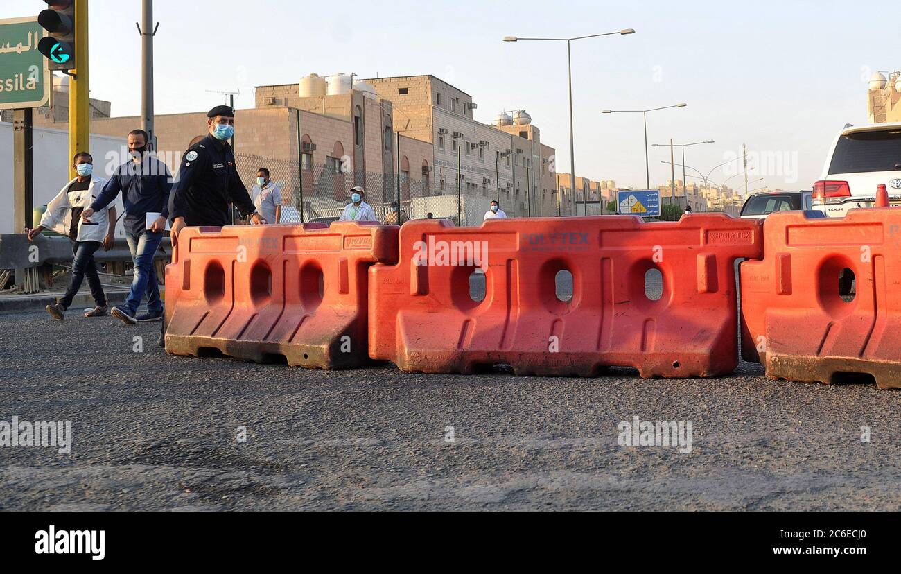 Kuwait-Stadt, Kuwait. Juli 2020. Ein Polizist entfernt Straßensperren vom Eingang zum Jleeb Al-Shuyoukh Bereich nach der Aufhebung der Sperrbeschränkungen, in Farwaniya Governorate, Kuwait, 9. Juli 2020. Die kuwaitische Regierung hob am Donnerstag die Sperre in den Gebieten Jleeb Al-Shuyoukh und Mahboula auf. Die Sperre wurde den beiden im Ausland dominierten und stark besiedelten Gebieten seit dem 6. April auferlegt. Quelle: Asad/Xinhua/Alamy Live News Stockfoto