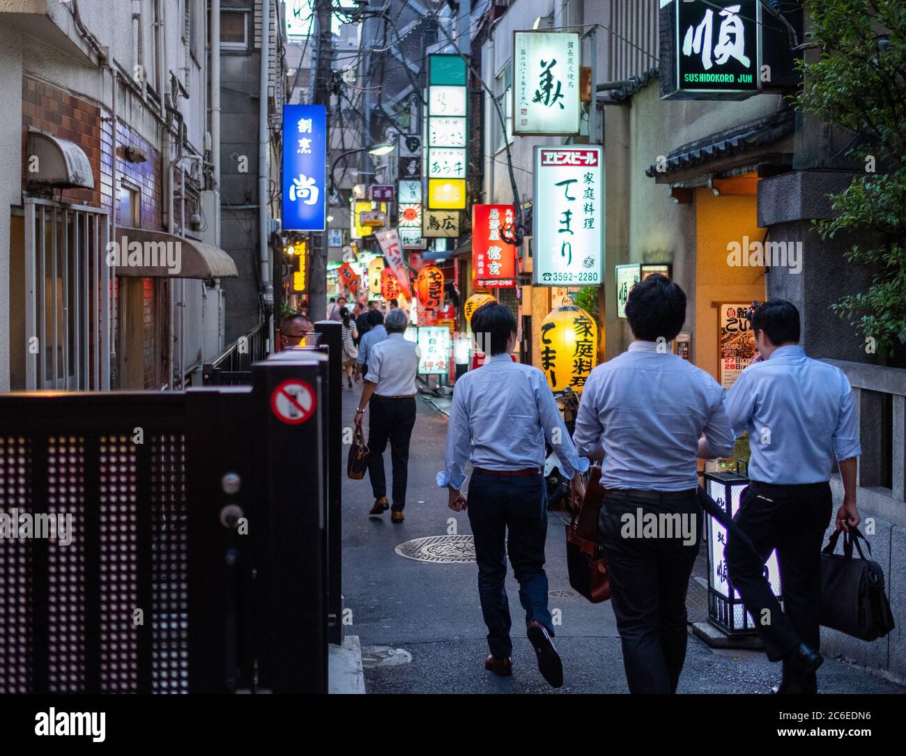 Menschen, die in der Hintergasse von Shimbashi spazieren, ein beliebtes Ziel für Büroangestellte in Tokio, Japan bei Nacht. Stockfoto