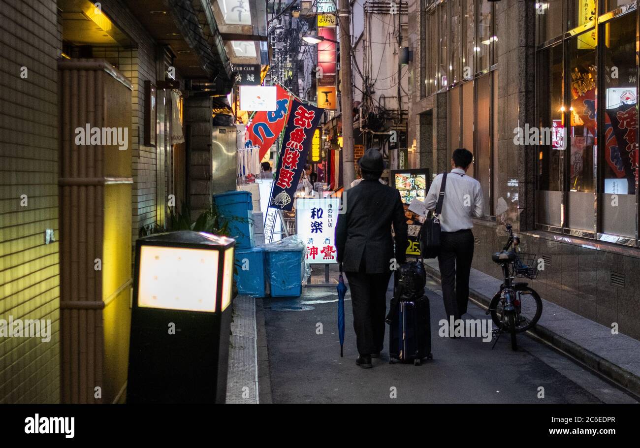Menschen, die in der Hintergasse von Shimbashi spazieren, ein beliebtes Ziel für Büroangestellte in Tokio, Japan bei Nacht. Stockfoto