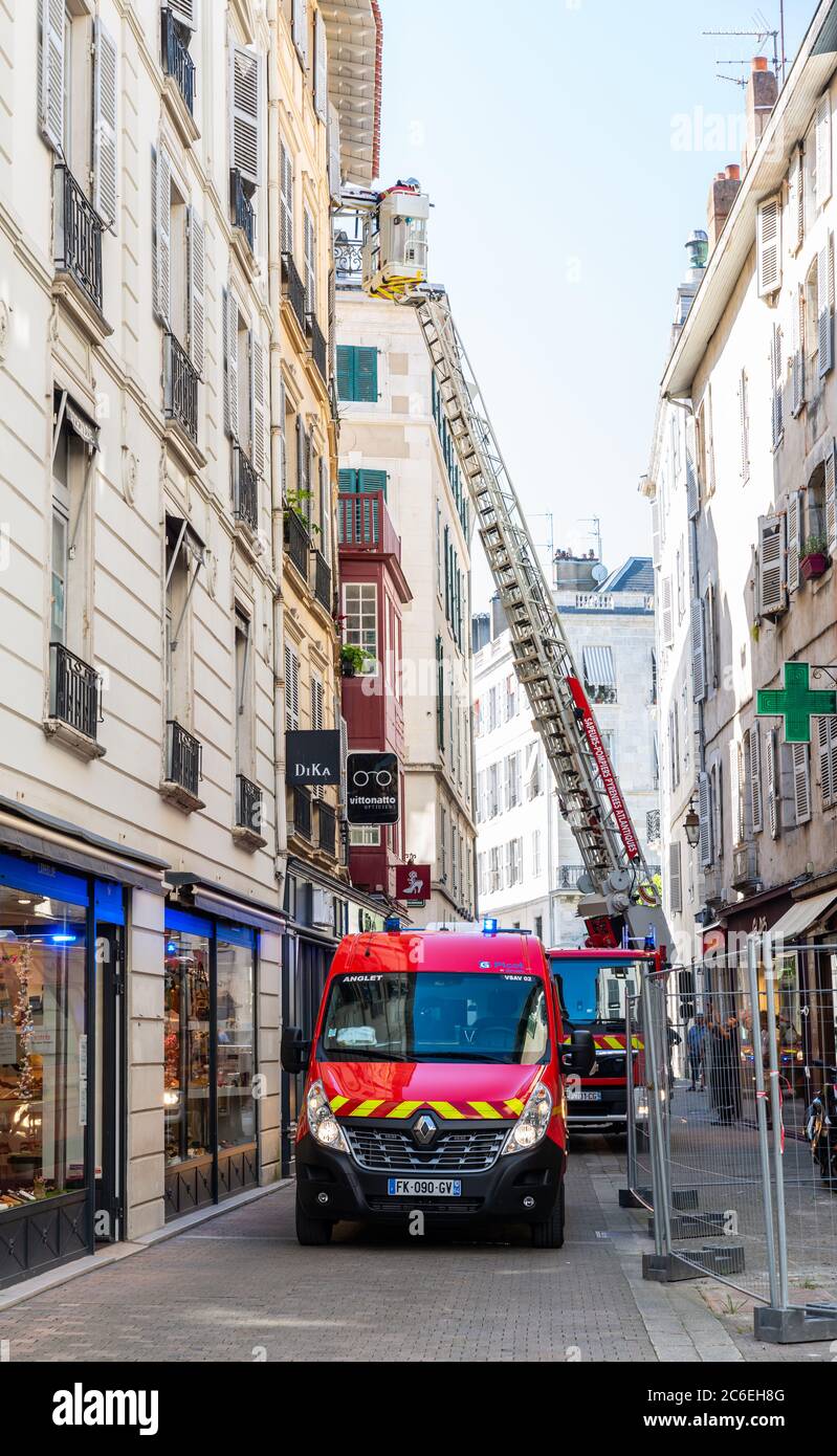 Feuerwehrleute evakuieren jemanden durch das Fenster, in Bayonne, Frankreich Stockfoto