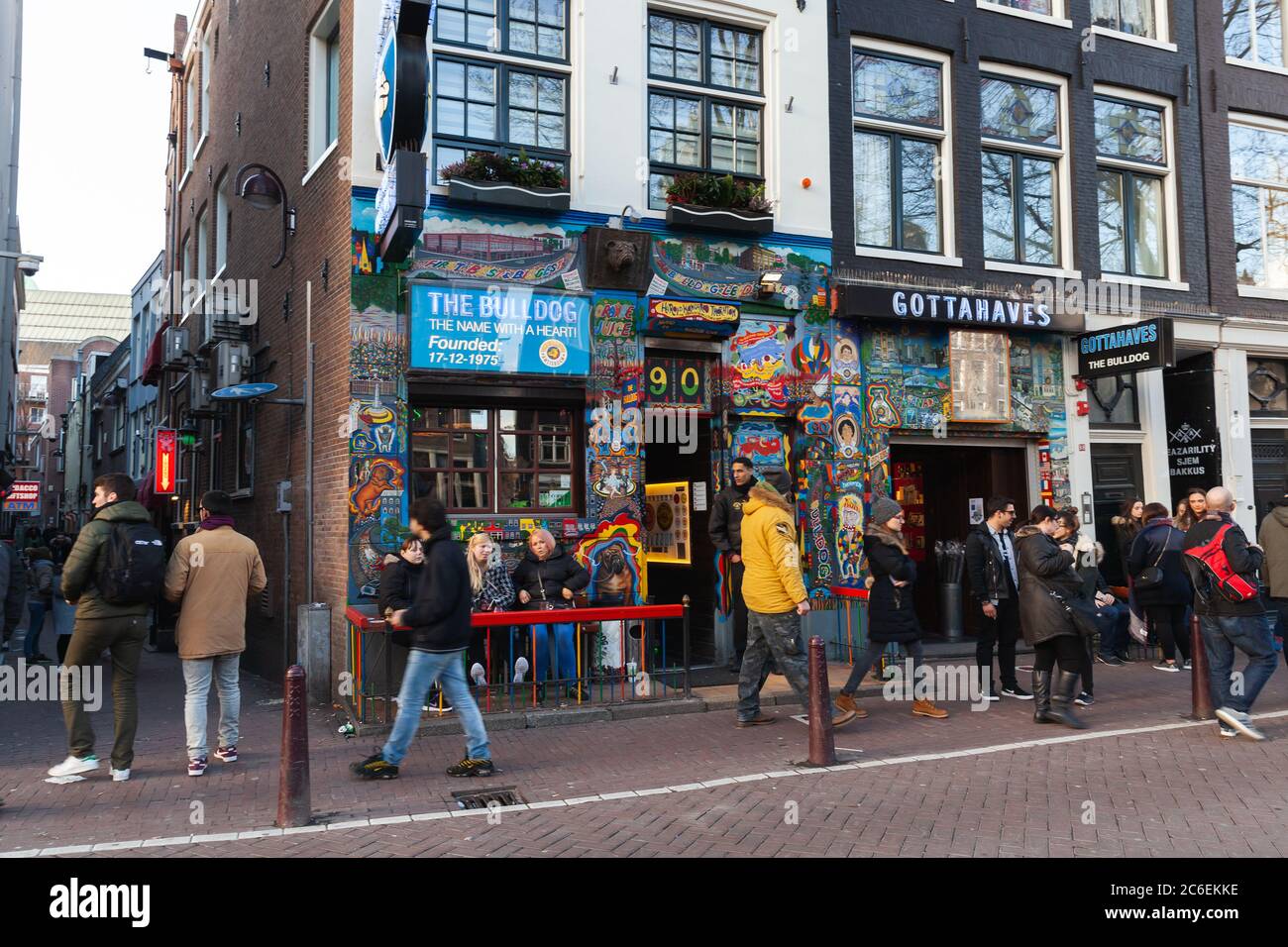 Amsterdam, Niederlande - 24. Februar 2017: Blick auf die Straße des alten Amsterdam mit Menschen, die in der Nähe von Coffeeshop Bulldog spazieren Stockfoto