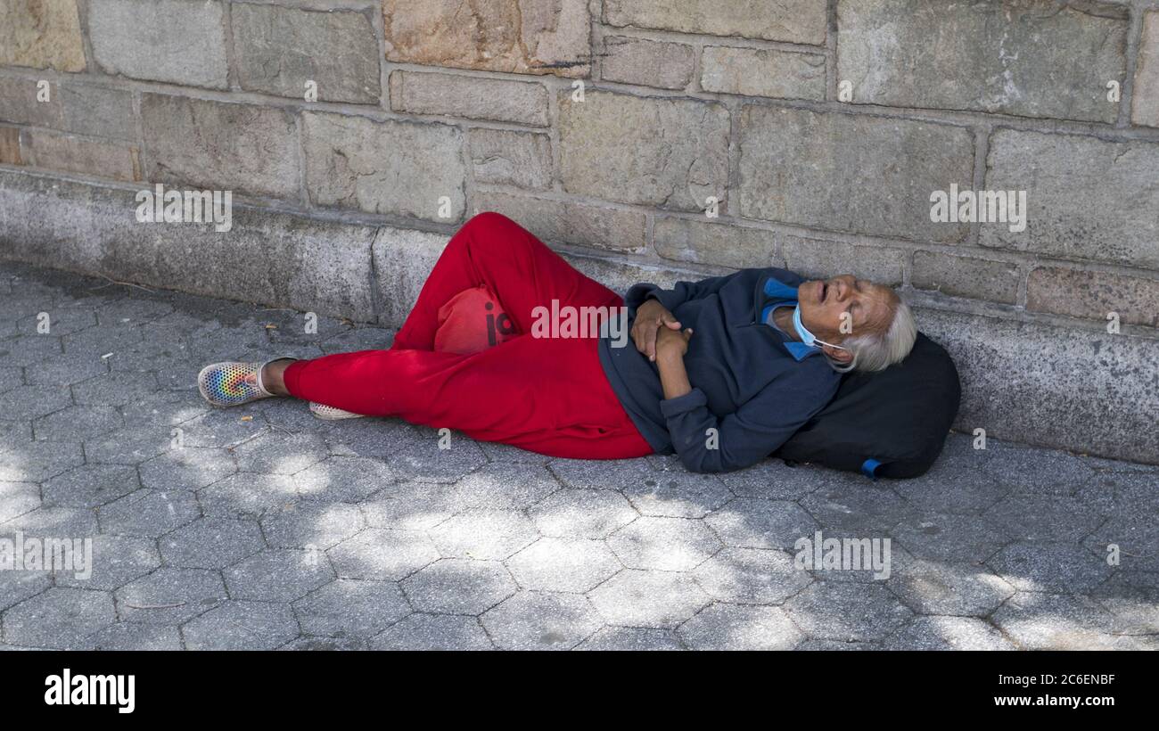 Ältere obdachlose Frau schläft auf dem Bürgersteig in Manhattan, NYC. Stockfoto
