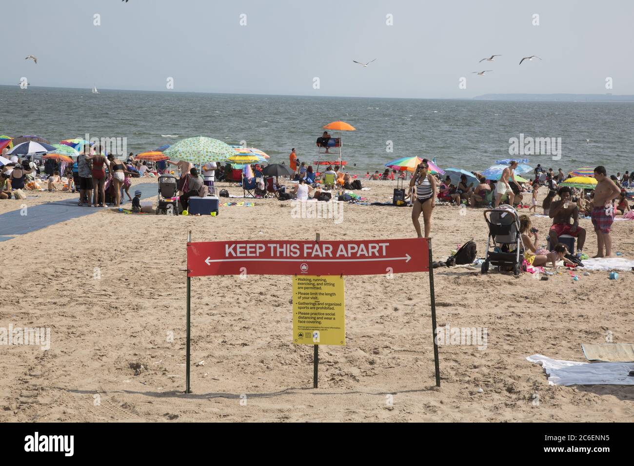 Mit dem Sommer hier beginnt der Strand von Coney Island trotz der Covid-19 Pandemie zu füllen. Die Menschen werfen ihre Masken in der Regel, während am Strand. Brooklyn, New York Stockfoto