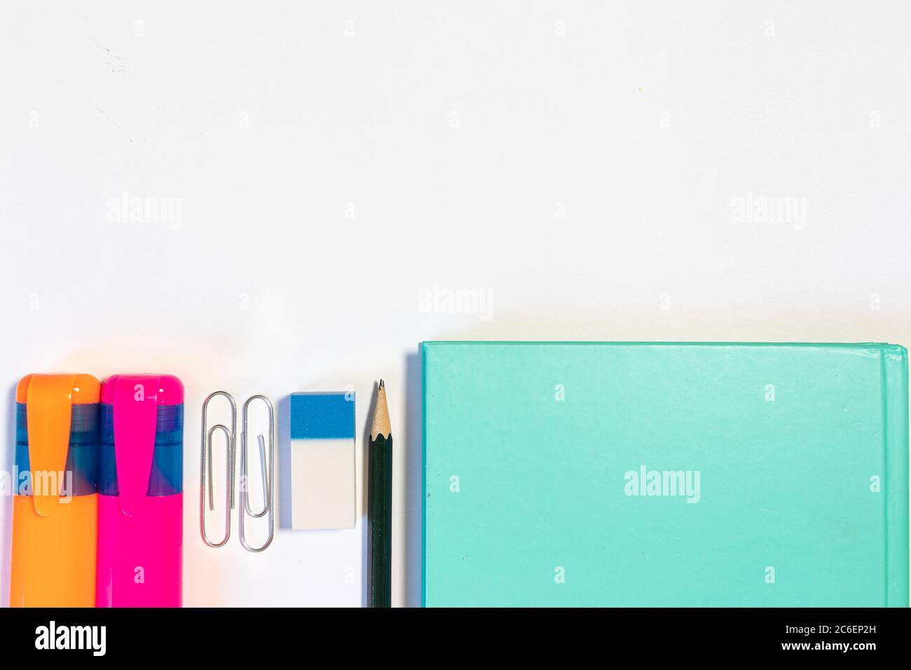 Büro- oder schulbezogene Objekte auf weißem Hintergrund: Notizbücher, Textmarker, Gummi, Bleistift, Clips Stockfoto