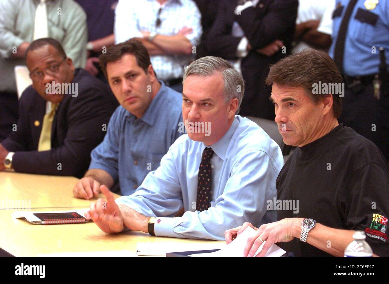 Houston, Texas USA, 2. September 2005: Der Gouverneur von Texas Rick Perry (rechts) koordiniert die Reaktion von Texas auf die massive Evakuierung der Einwohner von Süd-Louisiana, nachdem der Hurrikan Katrina die Region verwüstet hat. Perry trifft sich mit Beamten in der Reliant Arena mit Adam Bass (links) von Ameriquest, der 5 Millionen US-Dollar für Texas spendete, und Harris County Richter Robert Eckels (Mitte). ©Bob Daemmrich Stockfoto