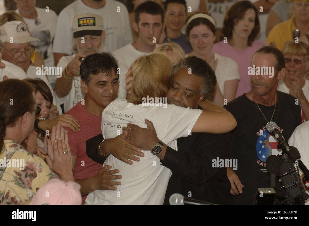 Crawford, Texas, 28. August 2005: Anti-Kriegs-Aktivistin Cindy Sheehan (links) umarmt Pfarrer Al Sharpton, als Sharpton einen Gottesdienst in Camp Casey II in der Nähe der Texas Ranch des US-Präsidenten George W. Bush durchführt. Sheehan, dessen Sohn Casey 2004 im Irak starb, hat während der Sommerferien des Präsidenten eine Reihe von Protesten in der Nähe der texanischen Ranch der Büsche organisiert. ©Bob Daemmrich Stockfoto