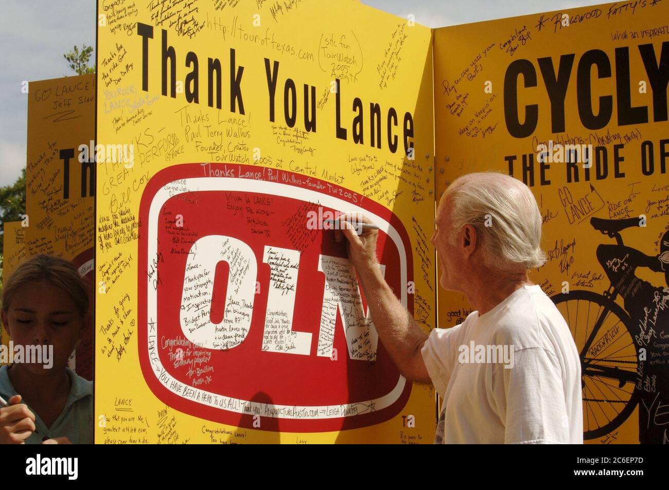 Austin, Texas USA, 24. Juli 2005: Radsportfans feiern den siebten Sieg des Heimathelden Lance Armstrong bei der Tour de France. Hunderte versammelten sich, um Botschaften auf großen Plakaten zu unterschreiben und das Finale in einem lokalen Einkaufszentrum im Freien zu sehen. ©Bob Daemmrich Stockfoto
