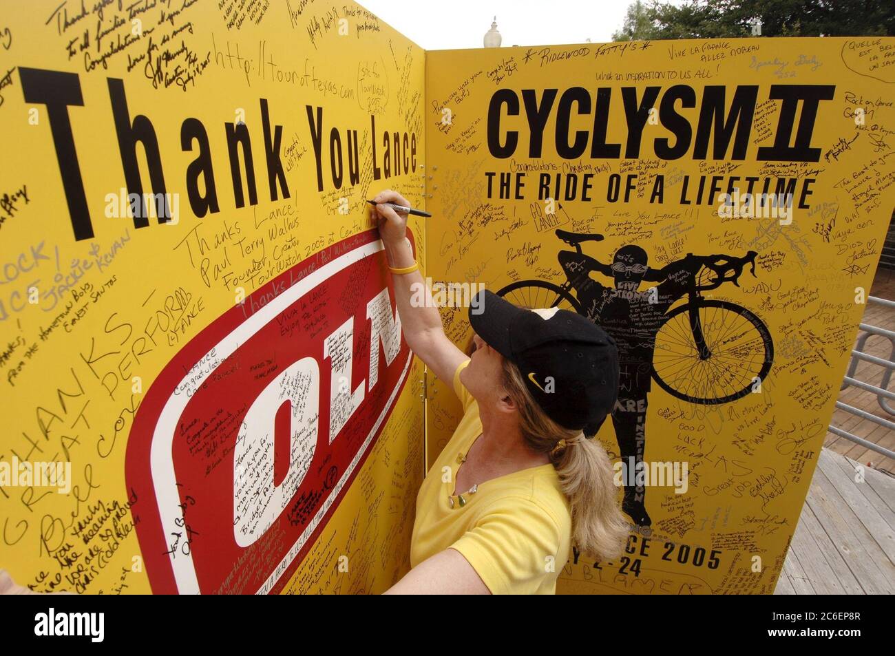 Austin, Texas USA, 24. Juli 2005: Radsportfans feiern den siebten Sieg des Heimathelden Lance Armstrong bei der Tour de France. Hunderte versammelten sich, um Botschaften auf großen Plakaten zu unterschreiben und das Finale in einem lokalen Einkaufszentrum im Freien zu sehen. ©Bob Daemmrich Stockfoto