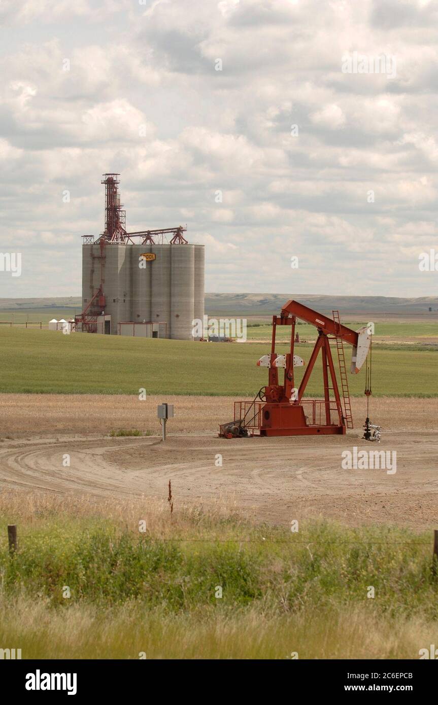 Southern Saskatchewan, Kanada 25. Juli 2005: Ölpumpenheber und Getreideaufzug entlang des Trans-Canada Highway im Südwesten von Saskatchewan. ©Bob Daemmrich Stockfoto