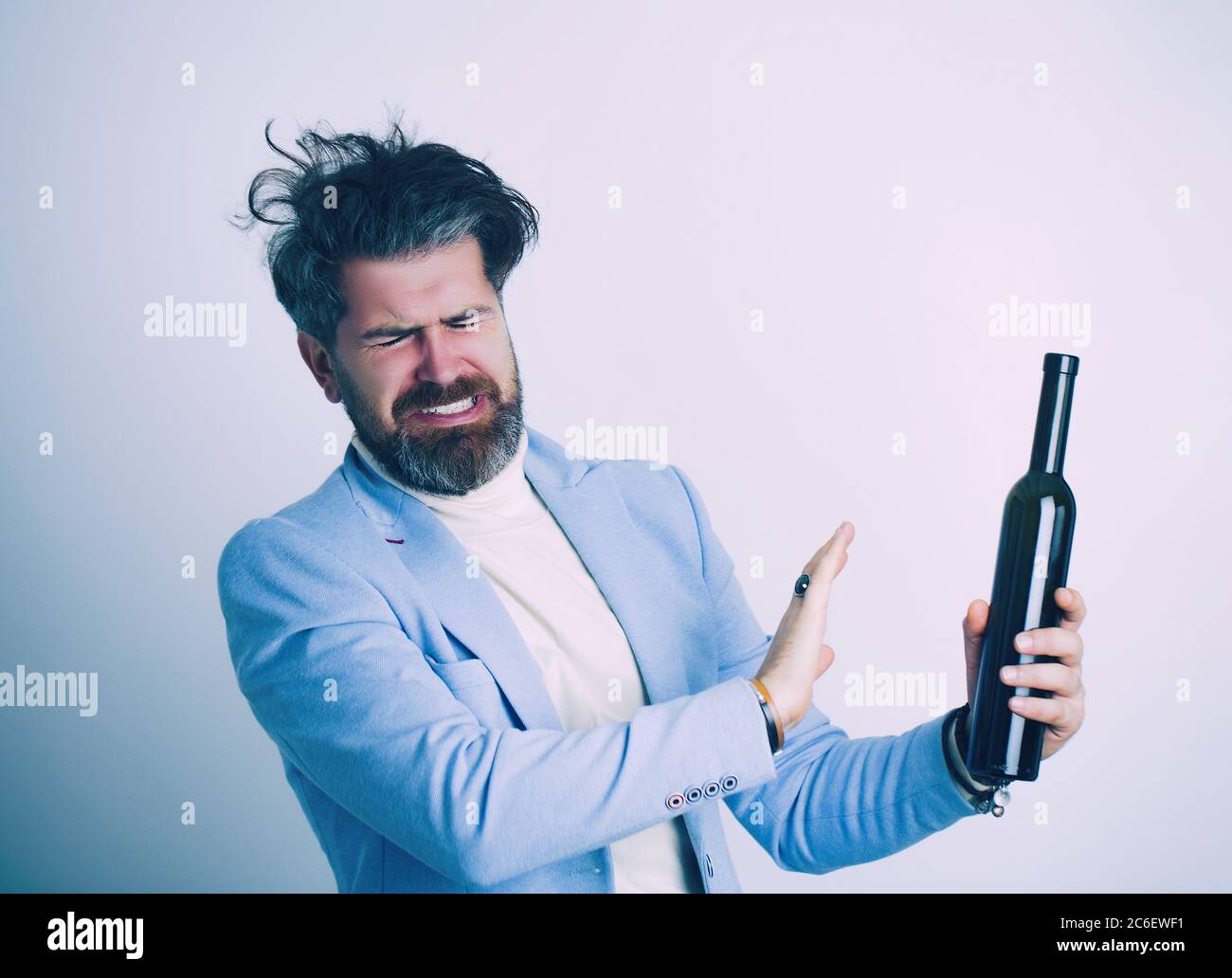 Betrunkener Mann in Bürokleidung mit einer Flasche Alkohol. Stockfoto