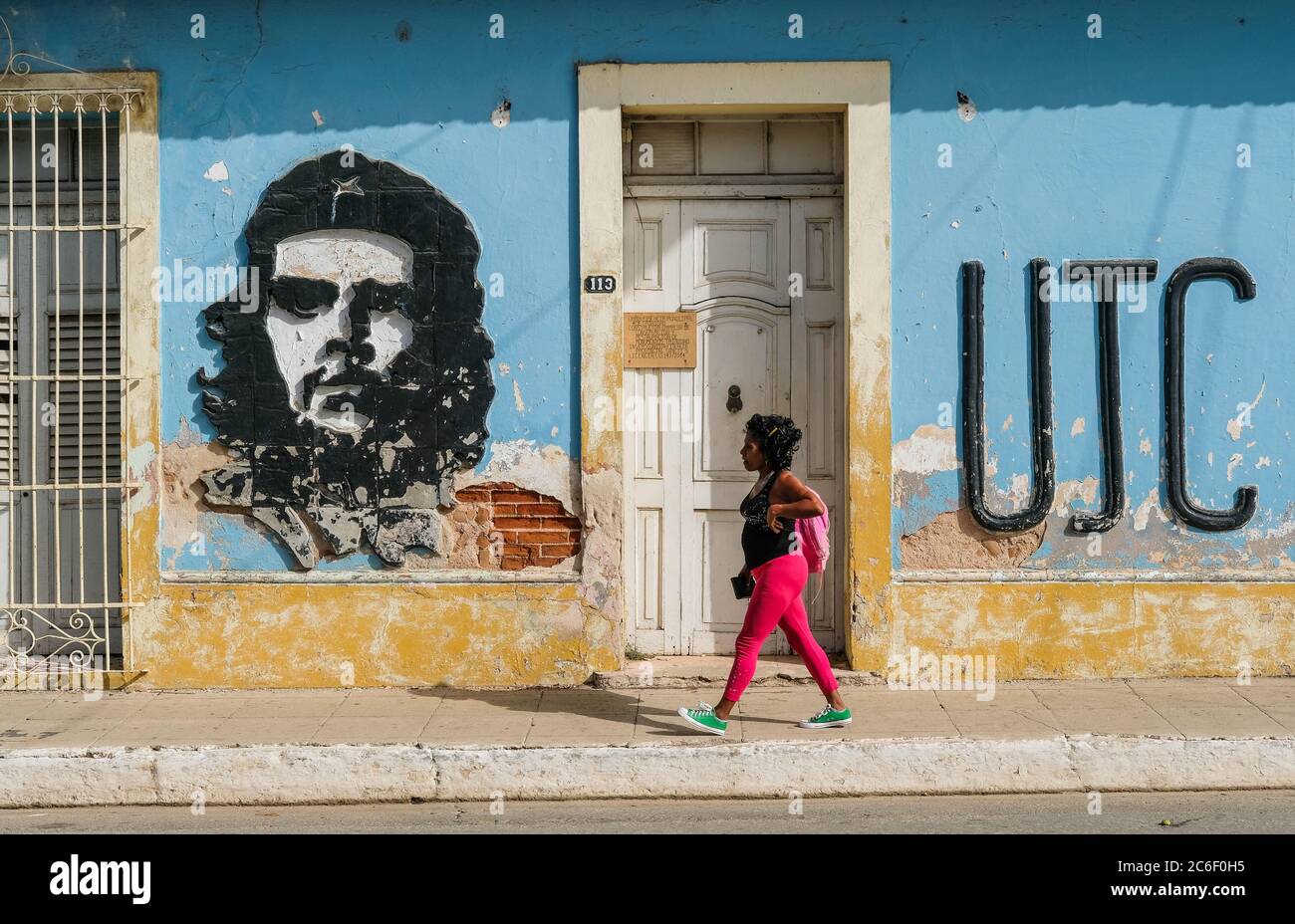 Eine Kubanerin geht an einem Bild von Che Guevara auf der Straßenseite in Trinidad, Kuba, vorbei. Stockfoto