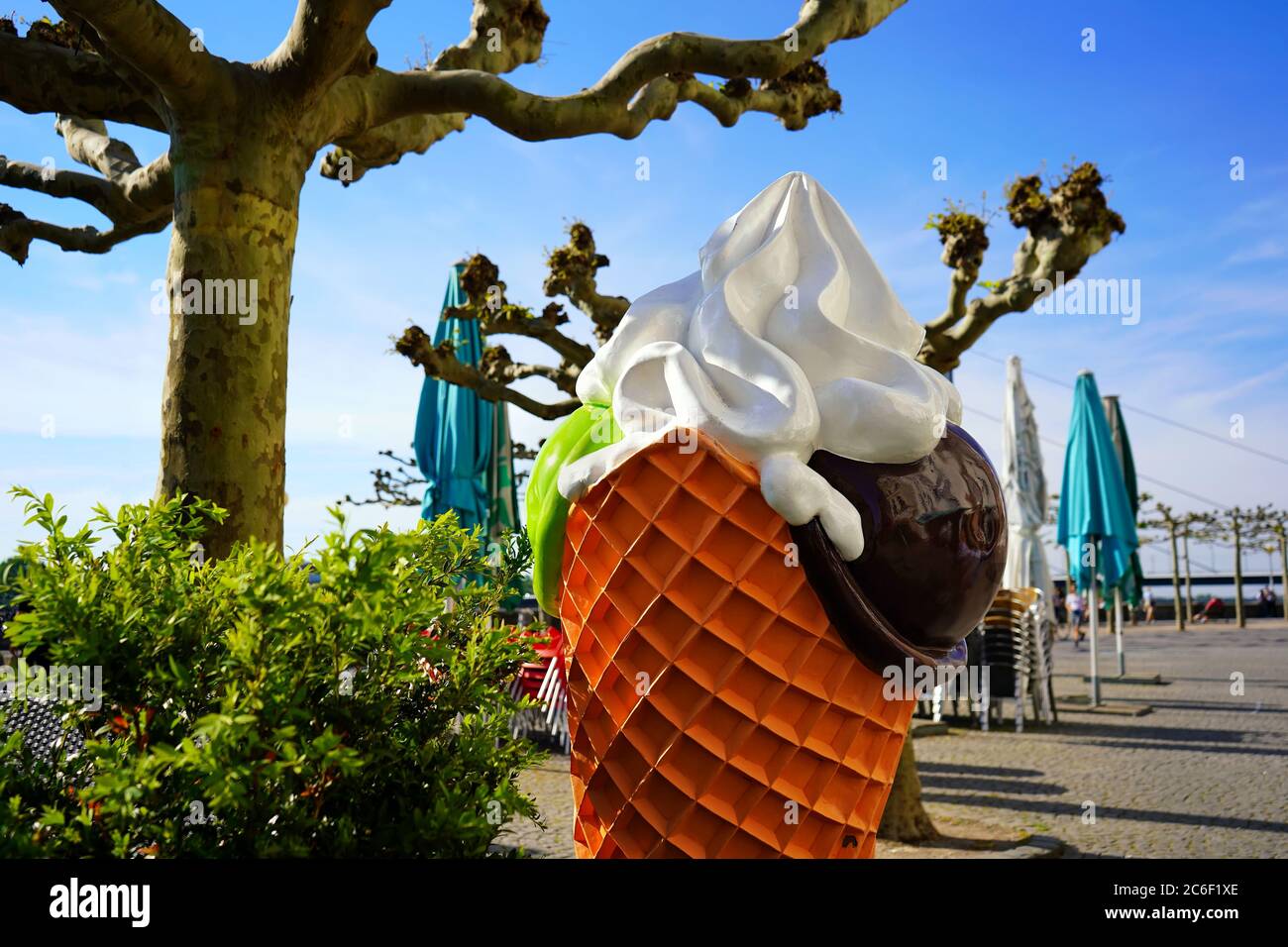 Sommer-Hintergrundbild mit selektivem Fokus auf einem dekorativen Eiskegel vor einem Café an der Rheinpromenade in Düsseldorf. Stockfoto