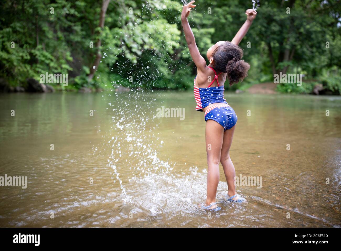 Ein junges Mädchen wackelt und spritzt im Shenandoah River, Virginia, USA. Stockfoto