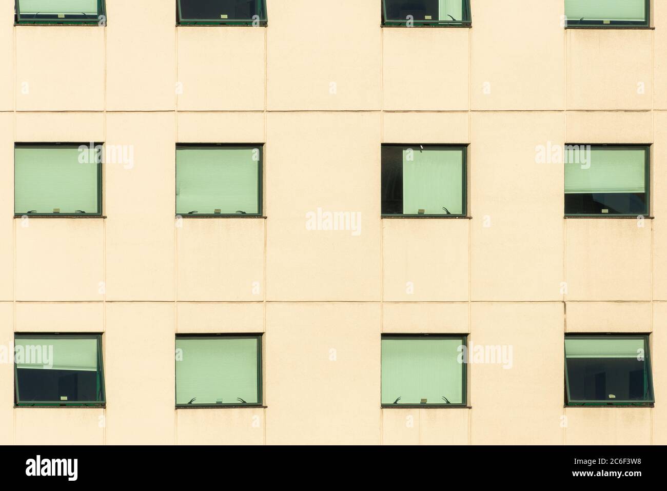 Fassade eines Gebäudes mit symmetrischen grünen Glasfenstern Stockfoto
