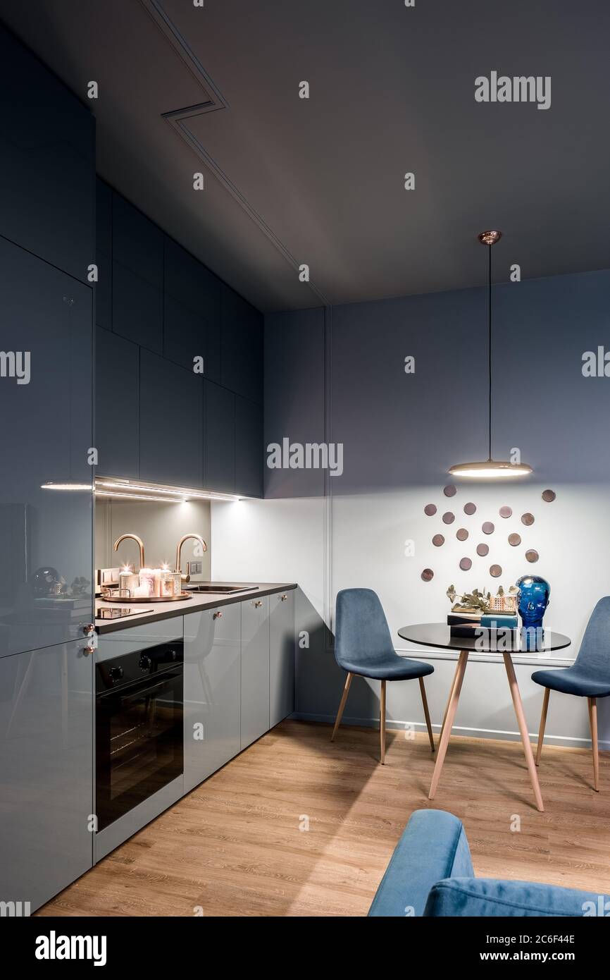 Dunkle Wohneinrichtung mit Küche und kleinem, runden Esstisch Stockfoto