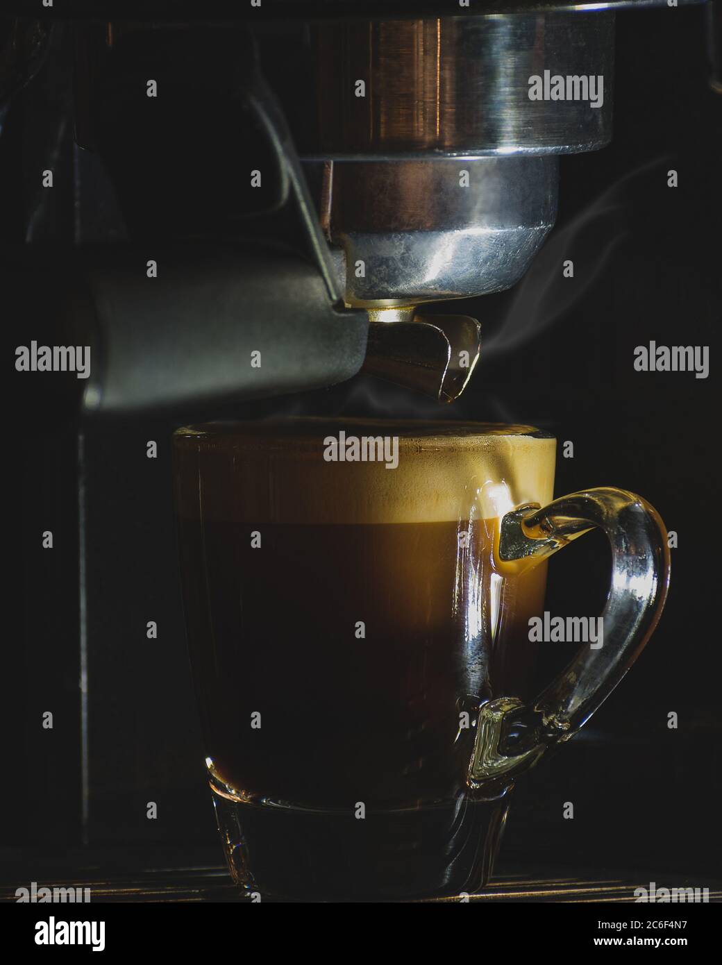 Volle Espressotasse in der Maschine, doppelter Schuss, heiße Kaffeebrühanlage Stockfoto