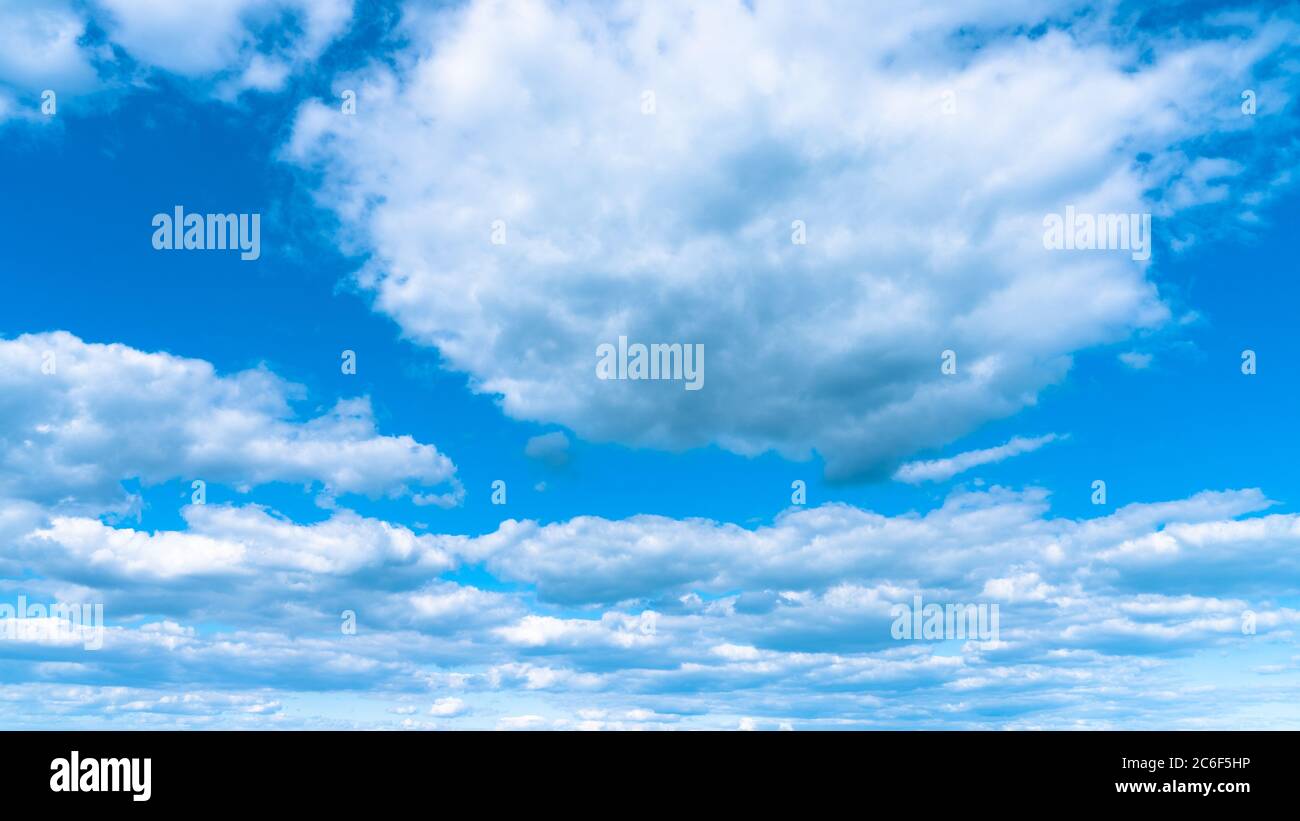 Landschaft weiße Wolken am blauen Himmel, atmosphärisches Wetterphänomen, natürliche chaotische Formen, die von der Natur geschaffen werden. Stockfoto