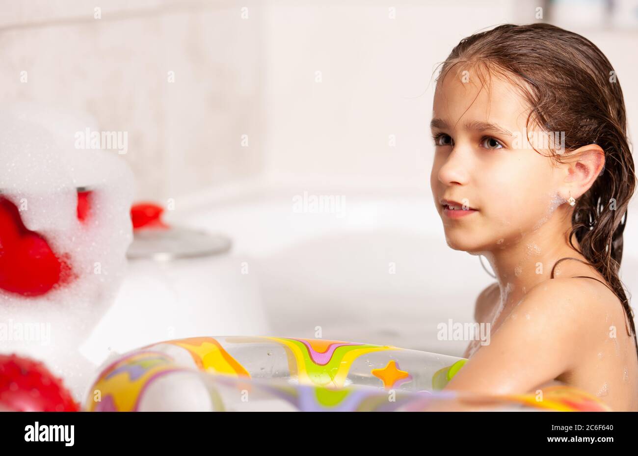 Lustige kleine Mädchen badet in einer Badewanne mit einer aufblasbaren