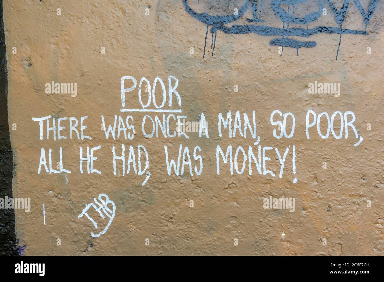 „Schlecht. Es war einmal ein Mann, so arm war alles, was er hatte, Geld!' Ein von Bob Marley inspiriertes Zitat an einer Wand am Rande von Hounslow Heath, Großbritannien. Stockfoto