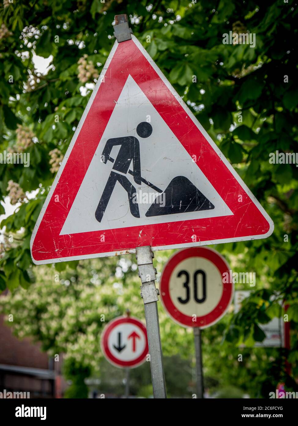 Gruppe von drei Verkehrswarnschildern in einer Reihe. Ort der Arbeit, Geschwindigkeitsbegrenzung 30, Priorität des entgegenkommenden Verkehrs Stockfoto