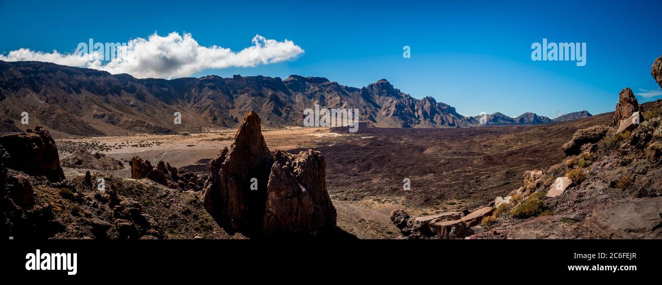 Horizontales Weitwinkelpanorama der trockenen vulkanischen Wüste mit rauen Felsen des beliebten teide Nationalparks in der Nähe des berühmten Wahrzeichen roques de garcia Stockfoto