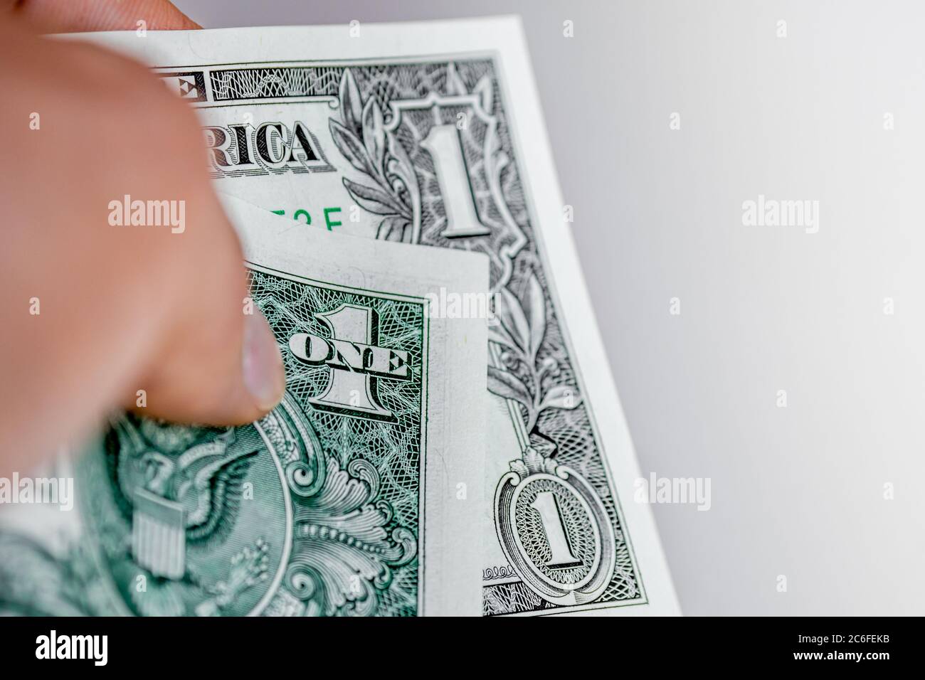 Schnappen Sie sich eine Dollar-Rechnung, erhalten Sie Trinkgeld, kleines Taschengeld oder Spende mit Kopierplatz auf der rechten Seite Stockfoto