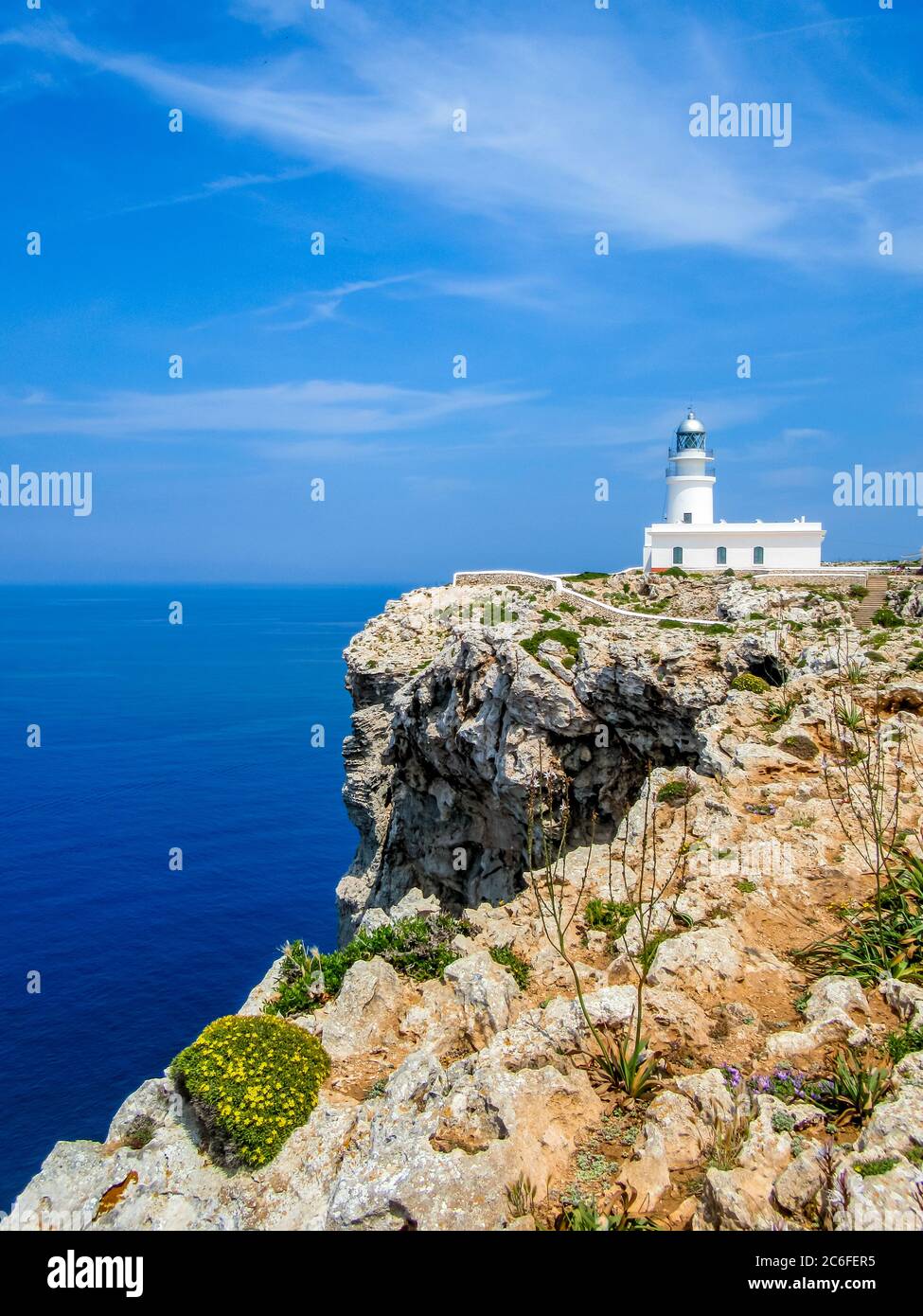 Idyllischer Blick auf den Leuchtturm des Kaps cavalleria vor steilen Klippen am mittelmeer bei es mercadal, menorca Stockfoto