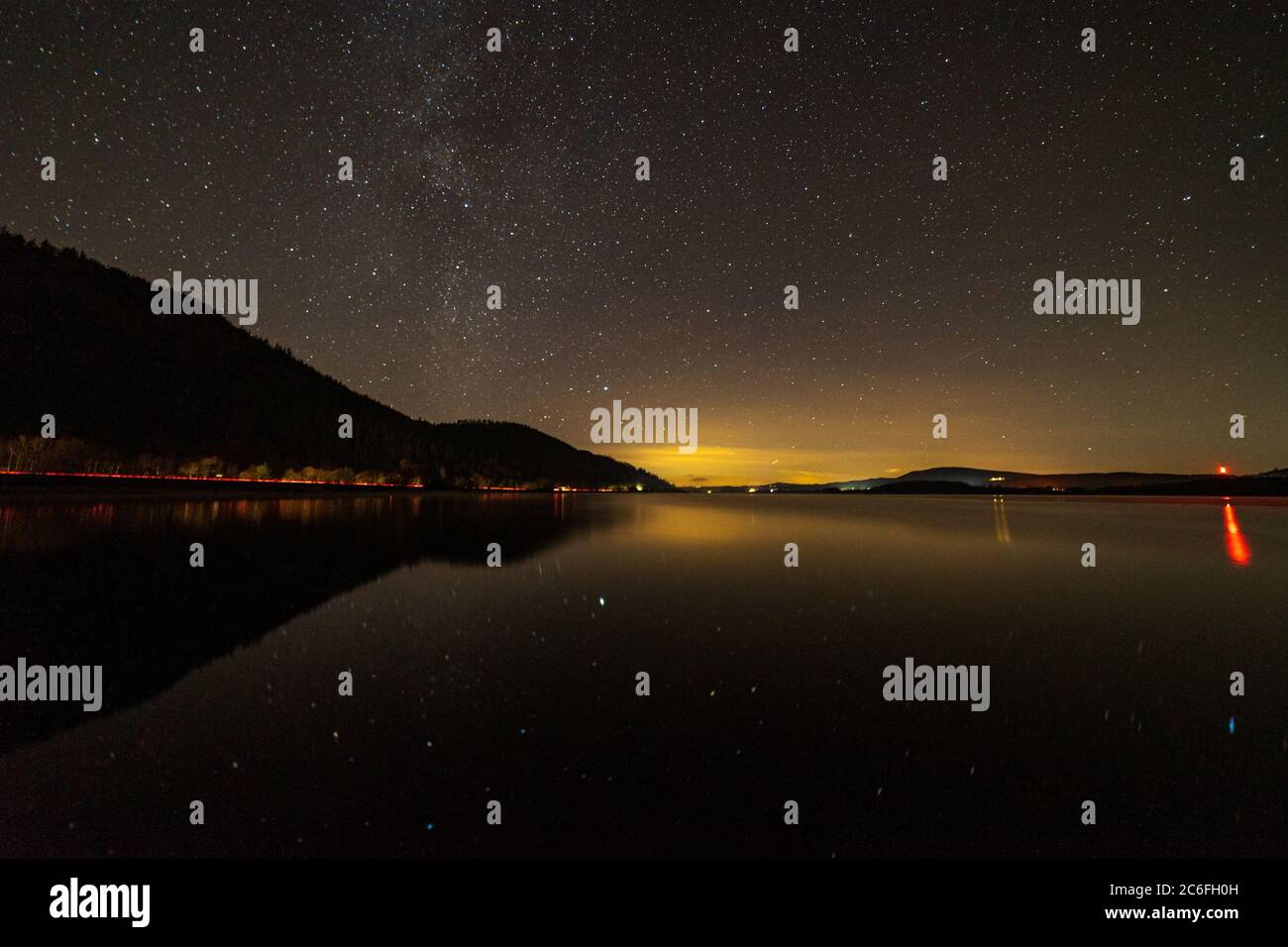 Bassenthwaite Lake im Seengebiet mit einer schwachen Milchstraße und Autoampeln auf der a66 Stockfoto