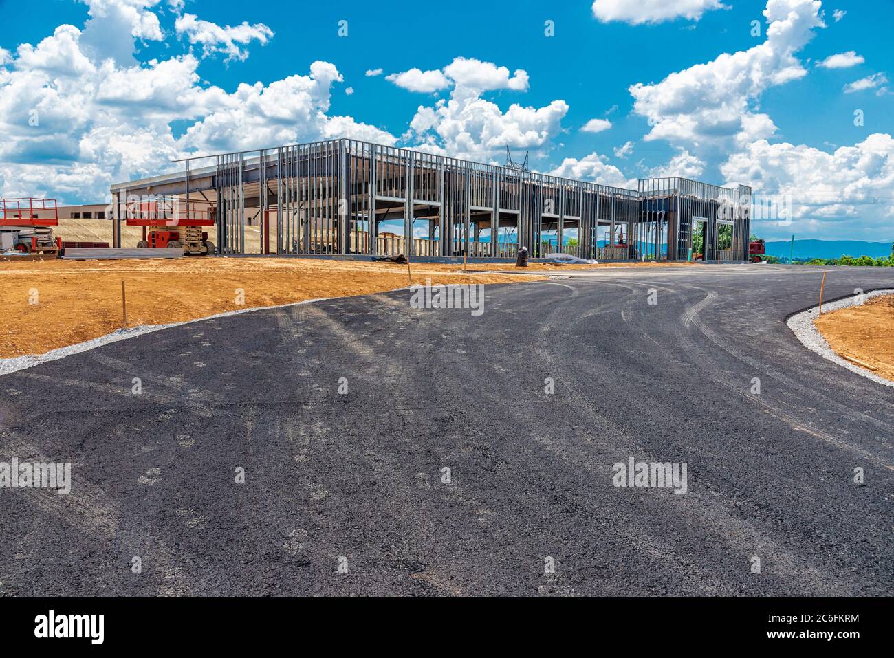 Horizontale Aufnahme des im Bau befindlichen Geschäftsgebäudes mit einem davor laufenden Antrieb. Stockfoto
