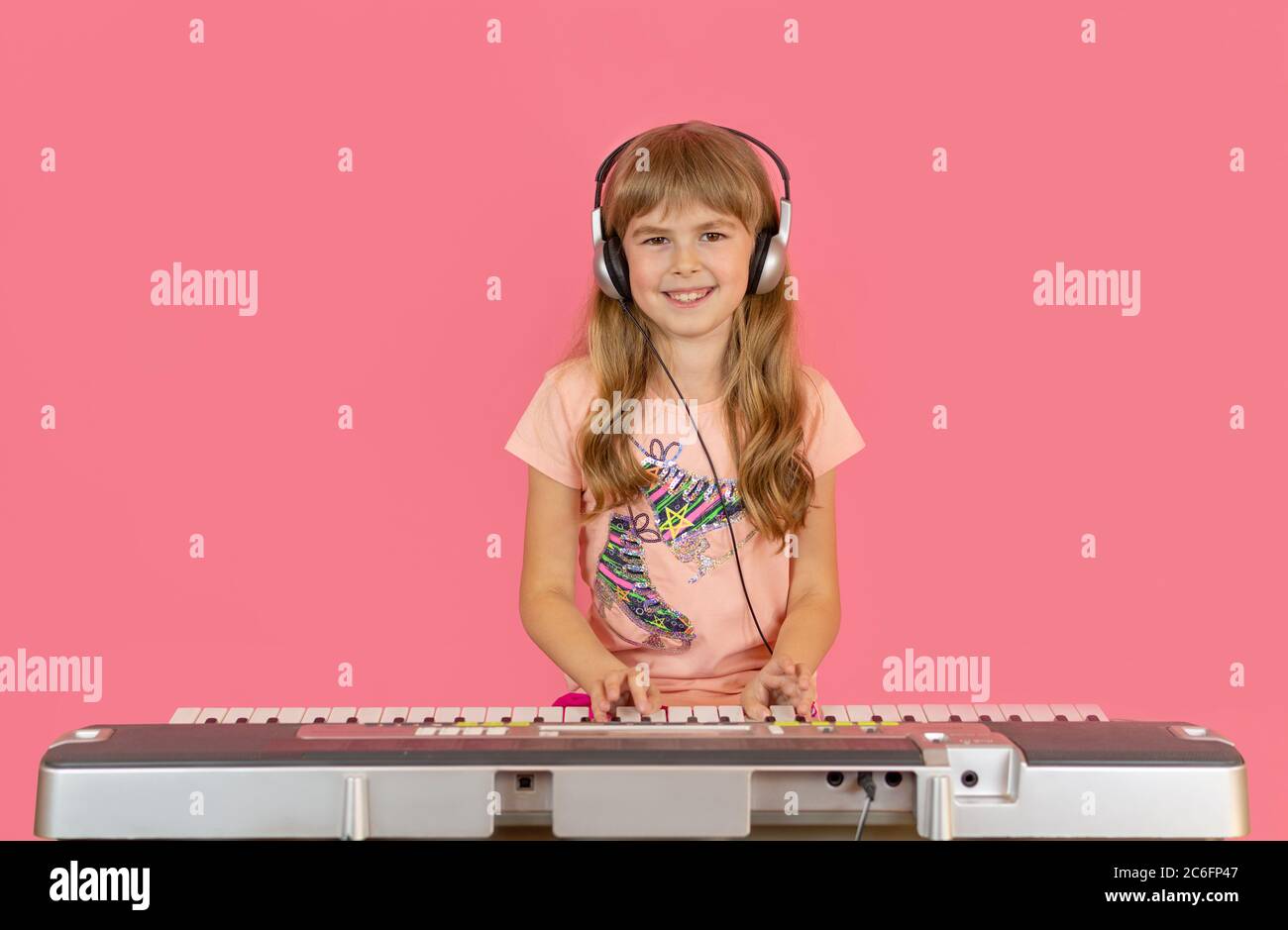 Nettes Mädchen spielt Synthesizer. Kleine Kinder spielen