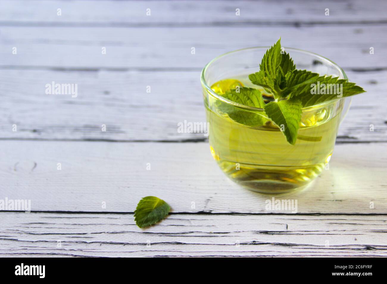 Frisches Minztee-Konzept auf Holzhintergrund. Minztee in einer Tasse, Stockfoto