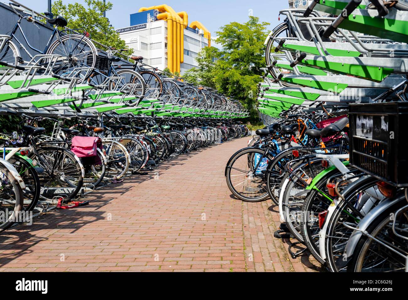 Zweigeschossiger Fahrradparkplatz am Bahnhof Rotterdam Blaak in den Niederlanden, mit Blick auf das Bibliotheksgebäude im Hintergrund. Stockfoto
