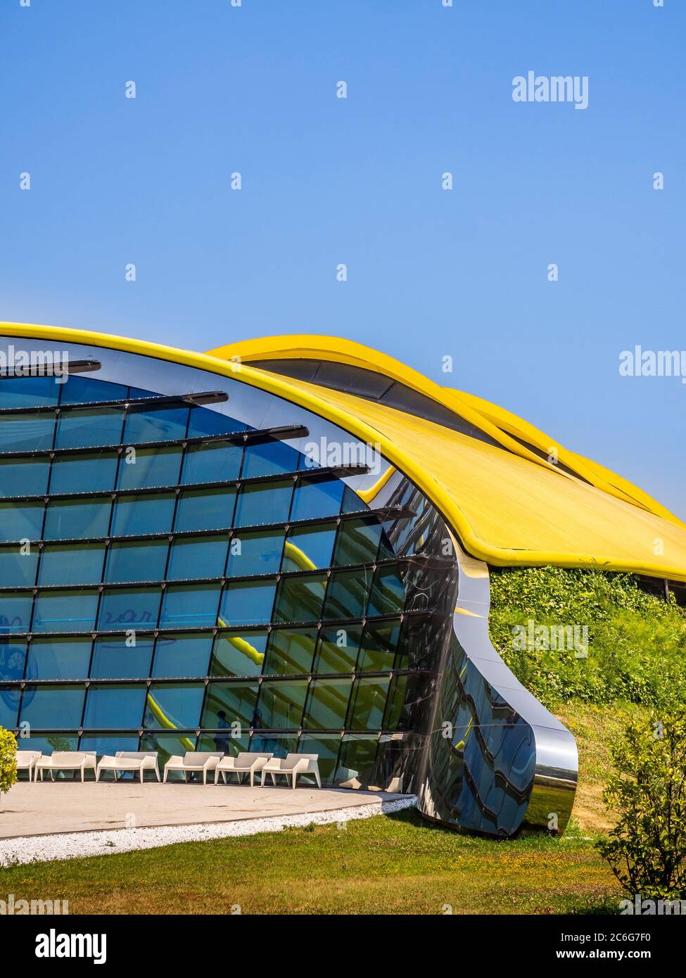 Modernes Äußeres des Enzo Ferrari Museums mit seinem geschwungenen gelben Dach. Modena, Italien. Stockfoto