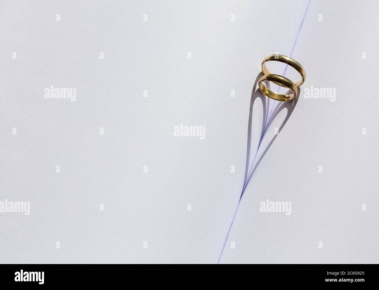 Zwei Ringe in der Falte eines leeren Buches, herzförmiger Schatten Stockfoto
