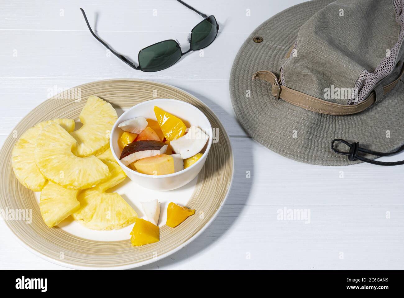 Ein Teller mit exotischen Früchten auf weißem Holztisch Stockfoto