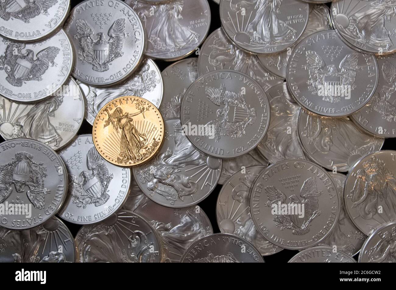 Stapel von American Eagle Silver Dollars mit einer Goldmünze auf der Oberseite Stockfoto
