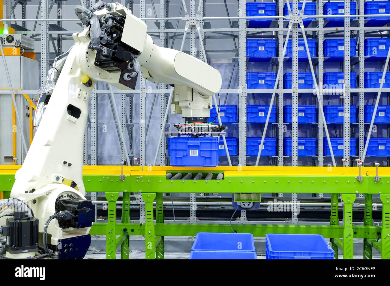 Industrielle Roboter greifen blauen Kunststoff-Box-Container auf Förderband für den Transport zur Lagerung auf intelligente Fabrik Lager gestellt Stockfoto