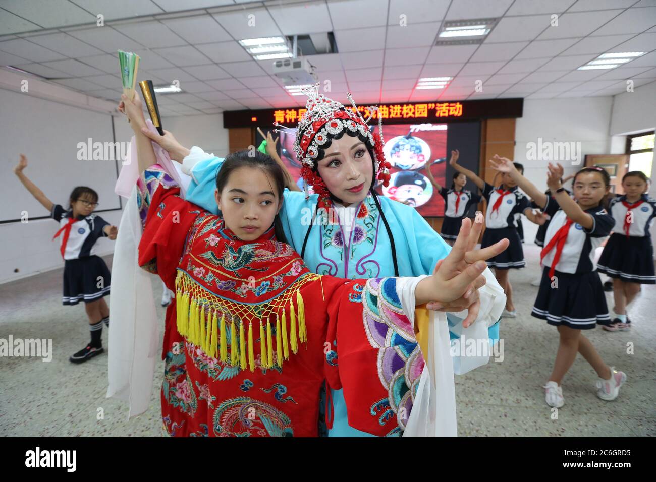 Von einer professionellen Schauspielerin der Peking-Oper unterrichtet, erleben lokale Grundschüler, die sich für das immaterielle Kulturerbe interessieren, Oper Stockfoto