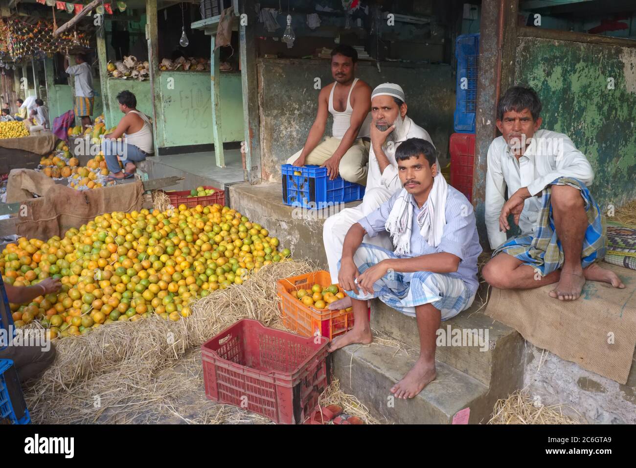 Markt Träger und. Verkäufer sitzen von Pfosten von Orangen in Byculla Markt in Mumbai, Indien, ein Großhandelsmarkt Obst und Gemüse Stockfoto