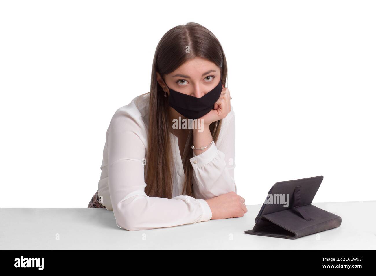 Eine Studentin in einer schwarzen medizinischen Maske und Fernunterricht. Arbeiten Sie von zu Hause aus. Ein Mädchen in Quarantäne studiert von zu Hause aus. Selbstisolierung und Quarantäne, zu Hause bleiben Stockfoto
