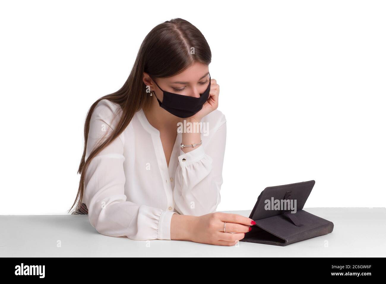 Ein Schüler in einer schwarzen medizinischen Maske und Fernunterricht. Arbeiten Sie von zu Hause aus. Ein Mädchen in Quarantäne studiert von zu Hause aus. Selbstisolierung und Quarantäne, zu Hause bleiben Stockfoto