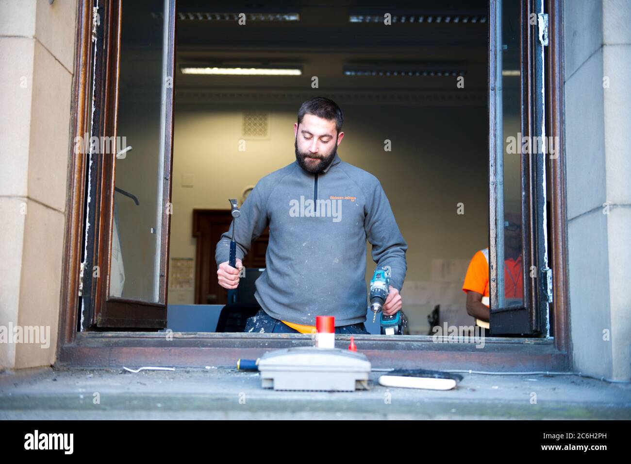 Glasgow, Schottland, Großbritannien. Juli 2020. Im Bild: Ein Tischler arbeitet an den Fenstern der Stadtkammern am George Square. Da die Sperre Bau- und Renovierungsarbeiten verhinderte, da die Sperre nachließ, können Tischler und Gewerke nun wieder an die Arbeit gehen, um die notwendige Wartung zu erledigen. Quelle: Colin Fisher/Alamy Live News Stockfoto